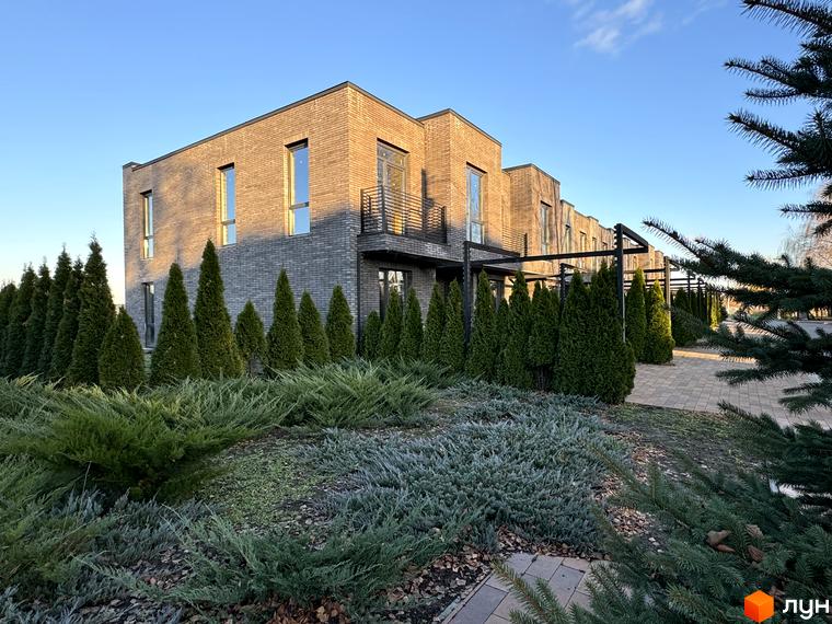 Цегляні таунхауси Eastville з панорамними вікнами та балконами. Доглянута прибудинкова територія з зеленими насадженнями.