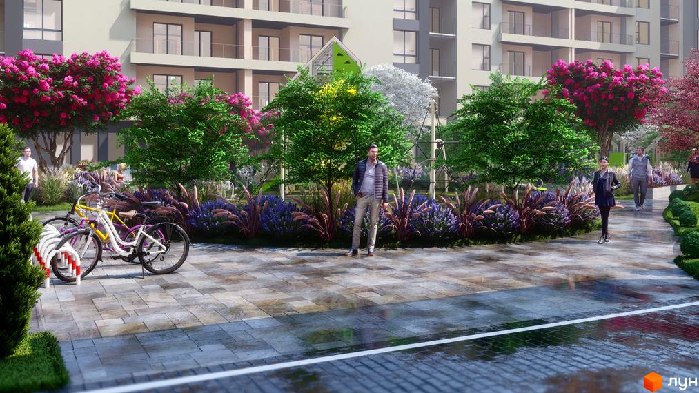 Багатоповерхові будинки Житлового комплексу GARDEN CITY зі світлими фасадами. Прибудинкова територія з деревами, яскравими квітами та доріжками.
