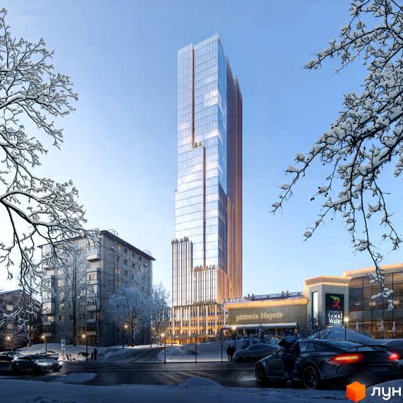 Високий скляний хмарочос THE ONE з коричневими елементами фасаду в зимовому міському пейзажі. Навколо засніжені дерева, вулиця з автомобілями та комерційні будівлі.