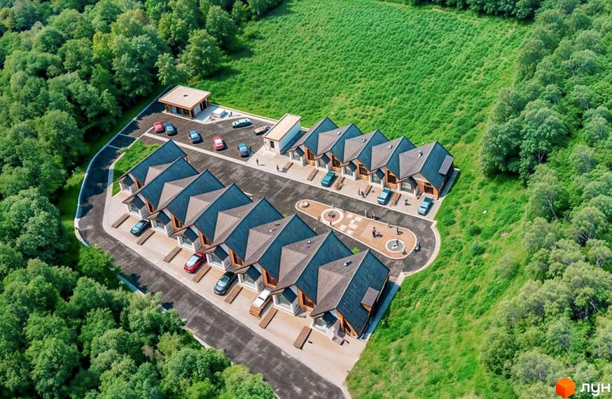 Таунхауси River Stone з двосхилими дахами та дерев'яними фасадами розташовані серед зелених насаджень, з прибудинковою територією та дитячим майданчиком.