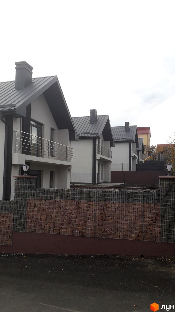 Новобудови на вул. Калинова: світлі будинки з темними дахами, балконами та кам'яною огорожею.