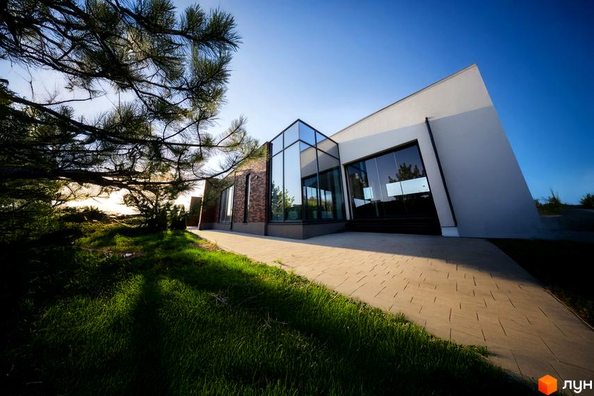 КМ Comfort City GREEN PARK: будівля з білим фасадом, скляними вікнами, цегляними вставками. Поруч газон, доріжка, сосна.