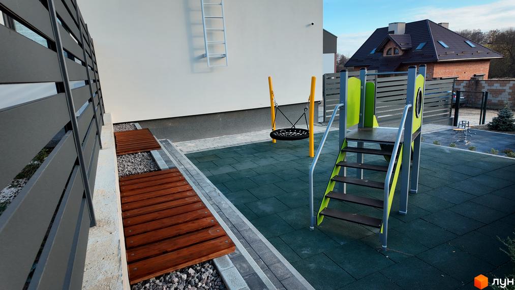 Таунхауси Motuz Hill: Білий будинок та дитячий майданчик з гіркою, гойдалкою і гумовим покриттям. Поруч зона відпочинку з дерев'яними лавками.