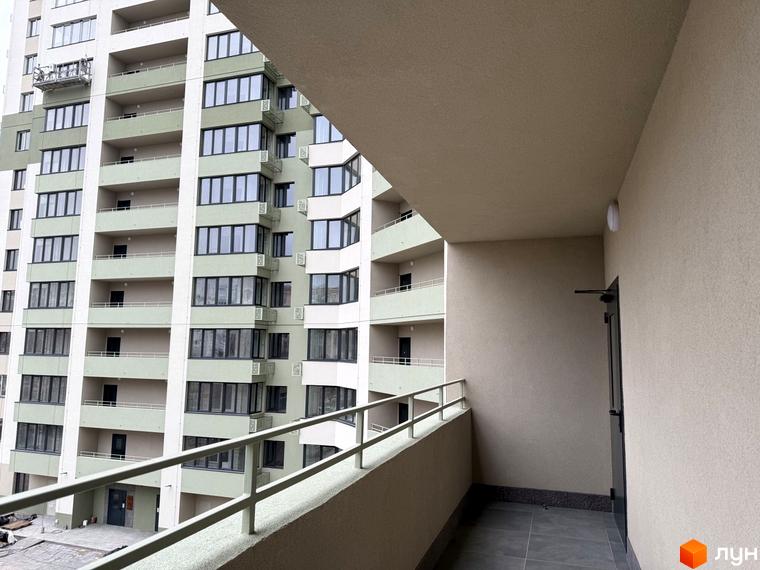 Житловий комплекс GRANIT: багатоповерховий будинок з світло-зеленим та білим фасадом, вікнами та балконами. Вид на внутрішній двір.