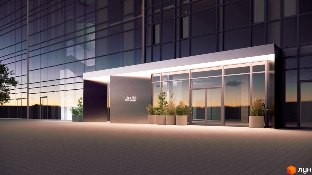 Вхід до новобудови Circle hotel&apartments зі скляним фасадом, що відбиває небосхил. Прибудинкова територія прикрашена рослинами у вазонах.
