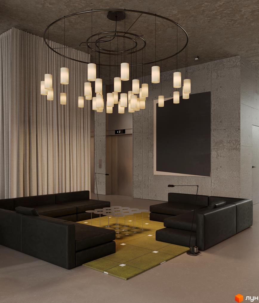 Інтер'єр лобі Circle hotel&apartments: зона відпочинку з диванами, підвісними світильниками та ліфтом у новобудові.