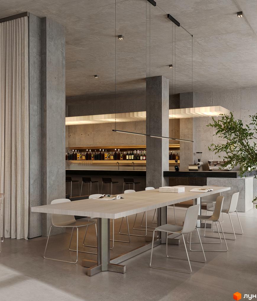Простора обідня зона та бар у новобудові Circle hotel&apartments з довгим столом та світлими стільцями.