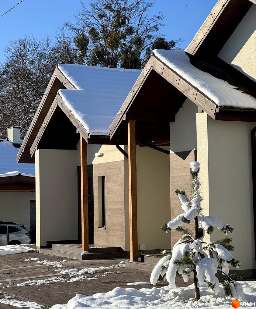 Котеджне містечко Буде Дім. Деревач: будинки з світлими фасадами та коричневими дахами, вкритими снігом. Прибудинкова територія із засніженими доріжками та деревами.