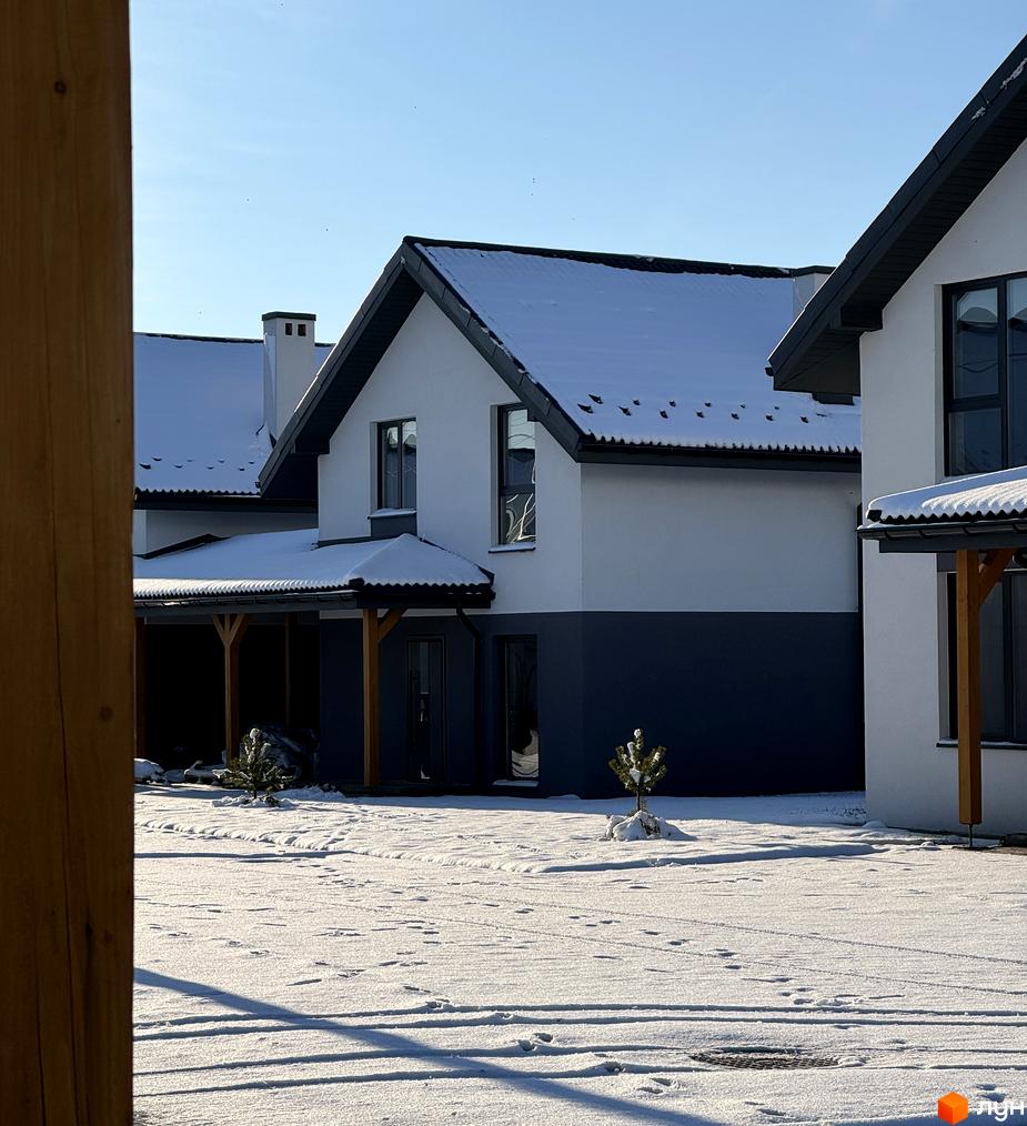 Будинки Котеджного містечка Буде Дім. Годовиця SPA з білими та темно-сірими фасадами, вкриті снігом. Навколо засніжений двір з деревом.