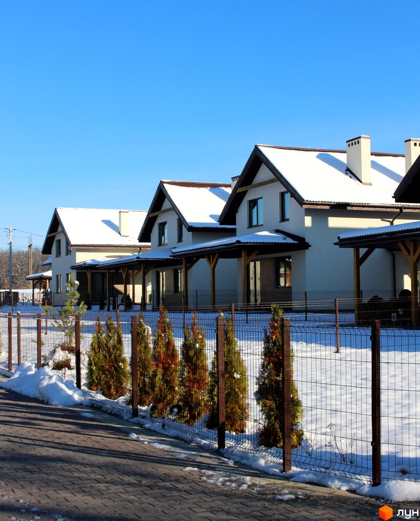 Котеджне містечко Буде Дім. Деревач: двоповерхові будинки з білими стінами та темними дахами, вкритими снігом. Прибудинкова територія зі снігом, огорожею та зеленими насадженнями.