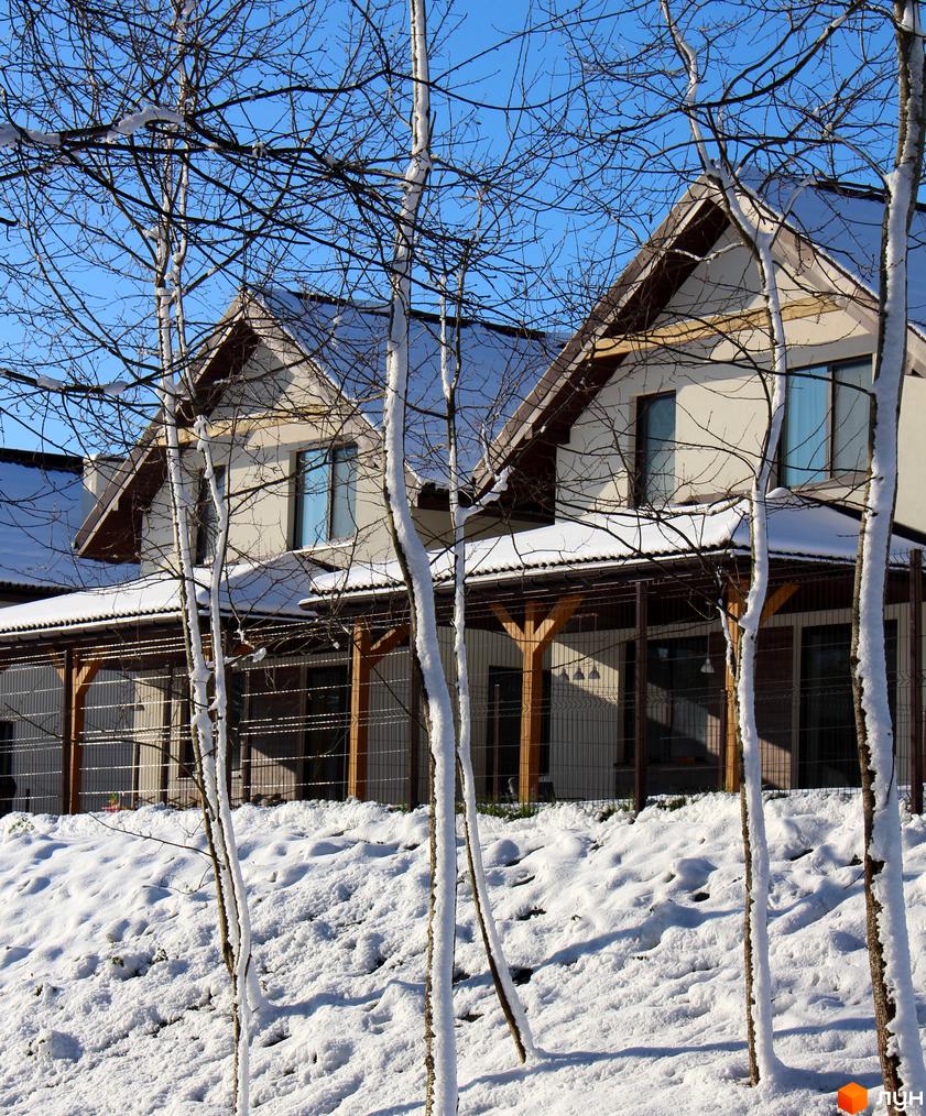 Котеджне містечко Буде Дім. Деревач: світлі двоповерхові будинки з темними дахами та критою терасою, оточені засніженим ландшафтом і деревами.