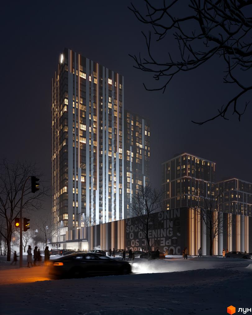 Житловий комплекс Avalon Up вночі з освітленими вікнами та вертикальними лініями на фасаді. На засніженій вулиці видно автомобілі та людей.