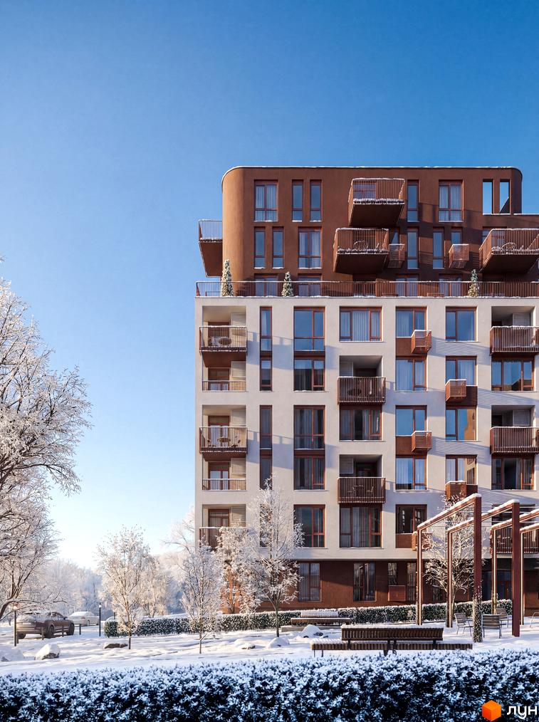 Житловий комплекс Avalon Terra: багатоповерховий будинок зі світлим фасадом та коричневими вигнутими верхніми поверхами. Засніжена прибудинкова територія з деревами та лавками.