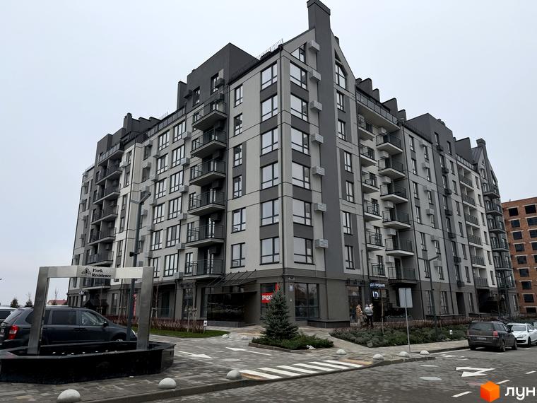 Будинок житлового комплексу Park Residence з великими вікнами та балконами, прибудинкова територія з зеленими насадженнями та парковкою.