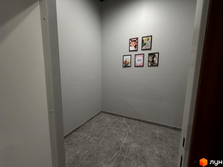 Внутрішній вигляд житлового комплексу Park Residence з сірою стіною та плитковою підлогою. На стіні розміщені фотографії.