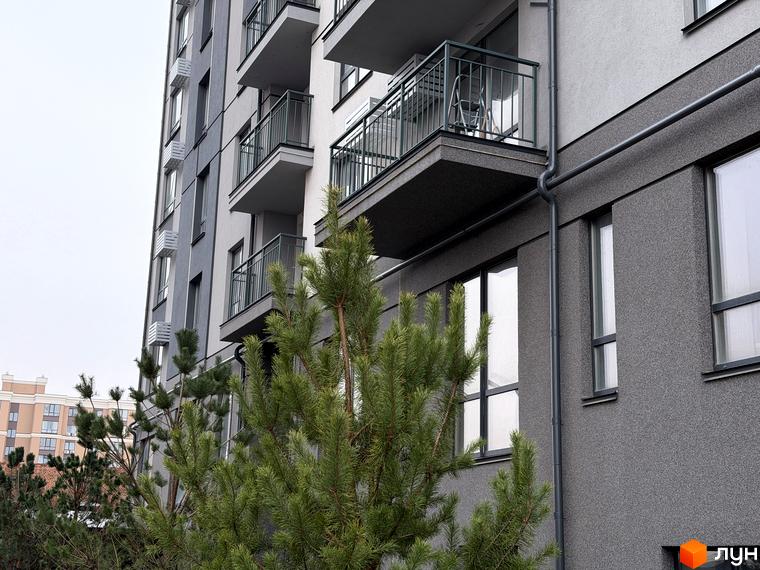 Зовнішній вигляд будинку ЖК Park Residence з балконами та сучасною фасадною обробкою, оточений зеленими насадженнями.