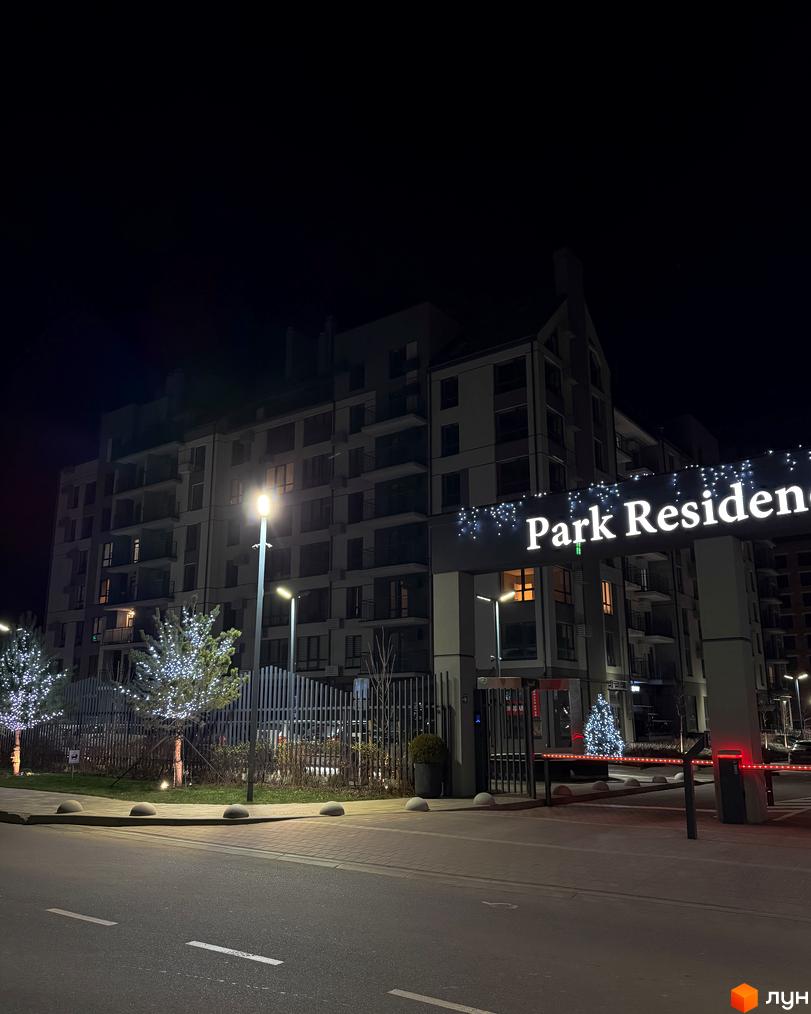 Житловий комплекс Park Residence вночі, з освітленими деревами та сучасним фасадом будинку.