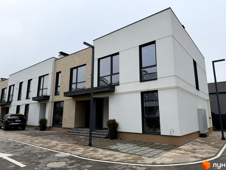 Житловий комплекс Таунхауси Soul City з сучасними будинками та прибудинковою територією з плиткою і зеленими насадженнями.