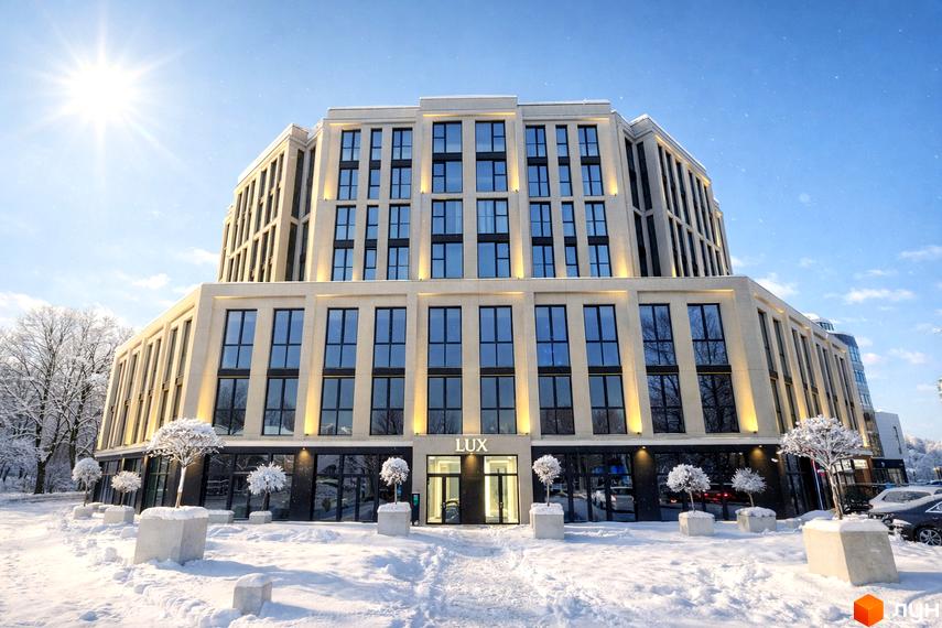 Житловий комплекс Standard LUX. Багатоповерховий будинок зі світлим фасадом та великими вікнами, оточений засніженою територією з декоративними деревами.