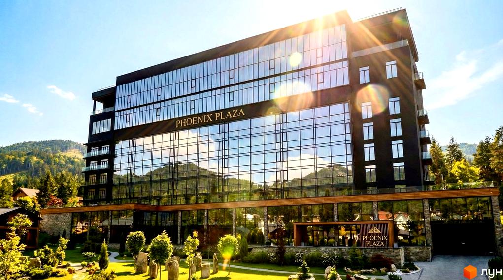 Сучасний будинок Апарт-готелю PHOENIX PLAZA з великими вікнами та прибудинковою територією, озелененою деревами та газонами.