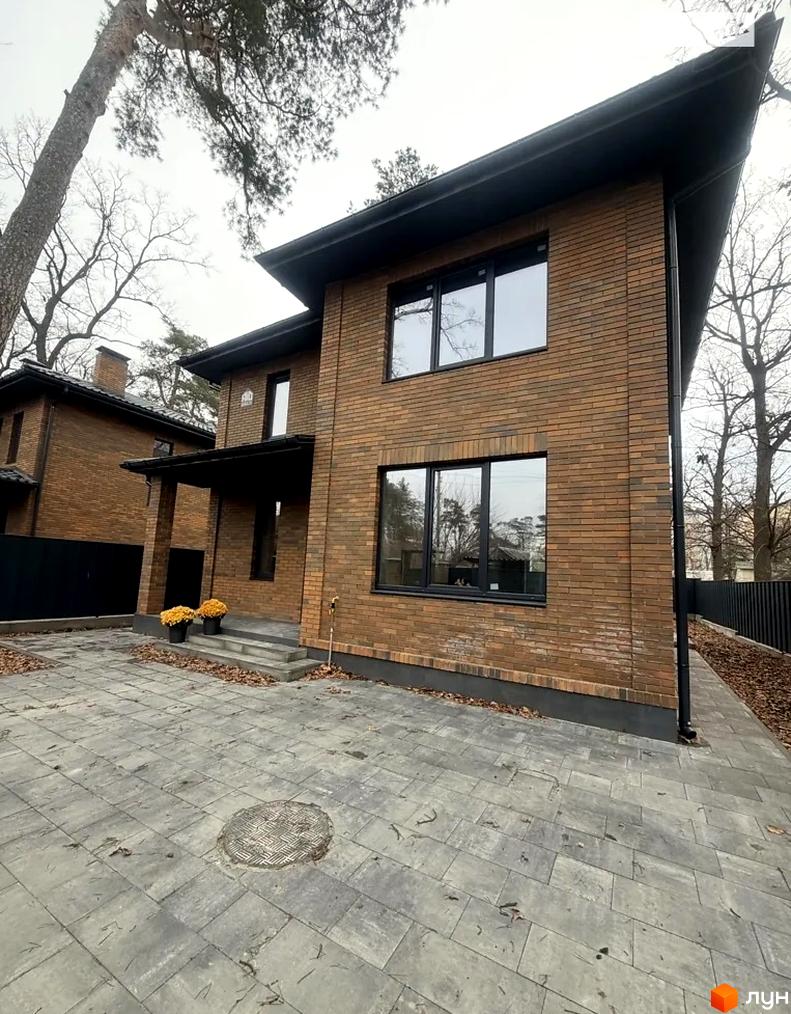 Будинок житлового комплексу КМ Провулок Північний 22 з цегляною фасадною обробкою та прибудинковою територією з плиткою.