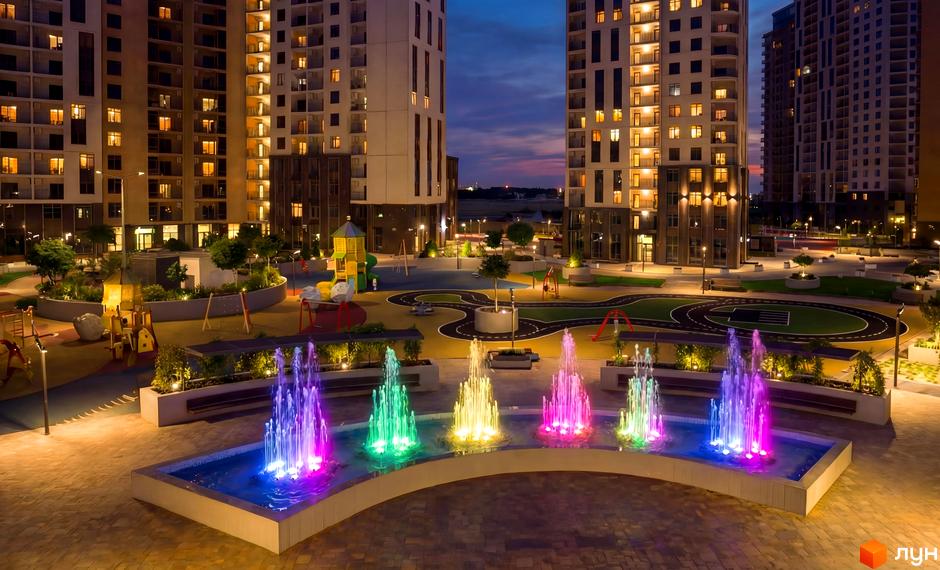 Житловий комплекс KADORR City з яскравими фонтанами та прибудинковою територією з дитячими майданчиками.