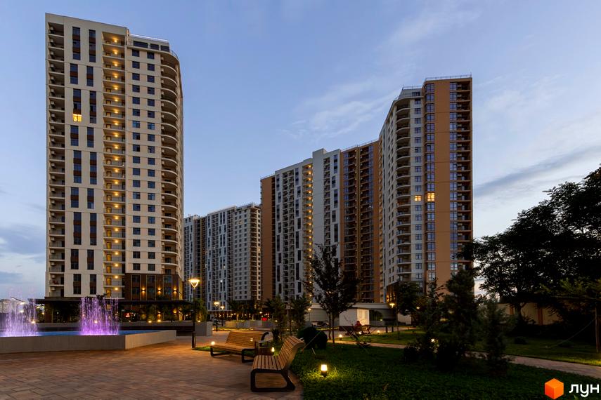 Житловий комплекс KADORR City з сучасними будинками та прибудинковою територією з фонтаном і зеленими насадженнями.