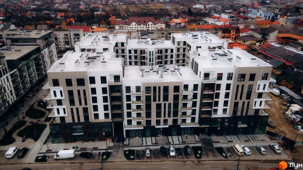 Житловий комплекс SKY CITY з сучасним фасадом та прибудинковою територією з зеленими насадженнями і парковкою.