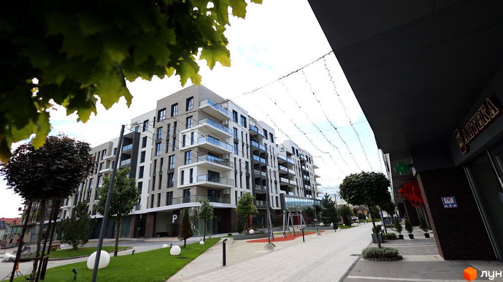 Житловий комплекс SKY CITY з сучасними балконами та прибудинковою територією, облаштованою зеленими насадженнями.