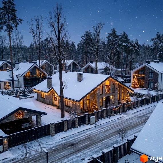 Зовнішній вигляд будинку Котеджного містечка КМ Park Residence 3 в зимовий період, прибудинкова територія з деревами та святковими прикрасами.