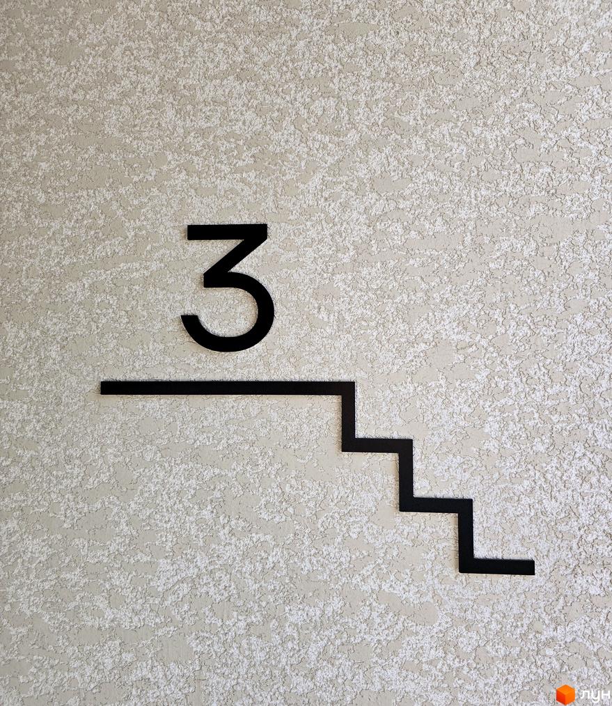 Номер поверху 3 на стіні житлового комплексу ЖК КОРОНА. Вид на текстуровану стіну з елементами декору.