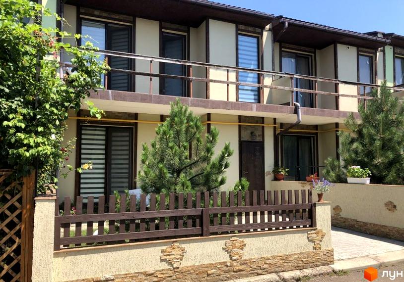 Зовнішній вигляд котеджного комплексу КМ Академічний з зеленими насадженнями та прибудинковою територією.