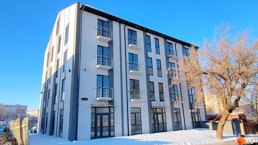 Зовнішній вигляд будинку житлового комплексу Успішний квартал 2 з балконами та прибудинковою територією, засніженою навколо.