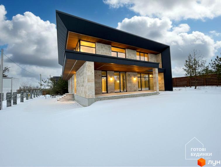 Зовнішній вигляд будинку житлового комплексу КМ Нова Ходосівка з великими вікнами та прибудинковою територією, засніженою взимку.