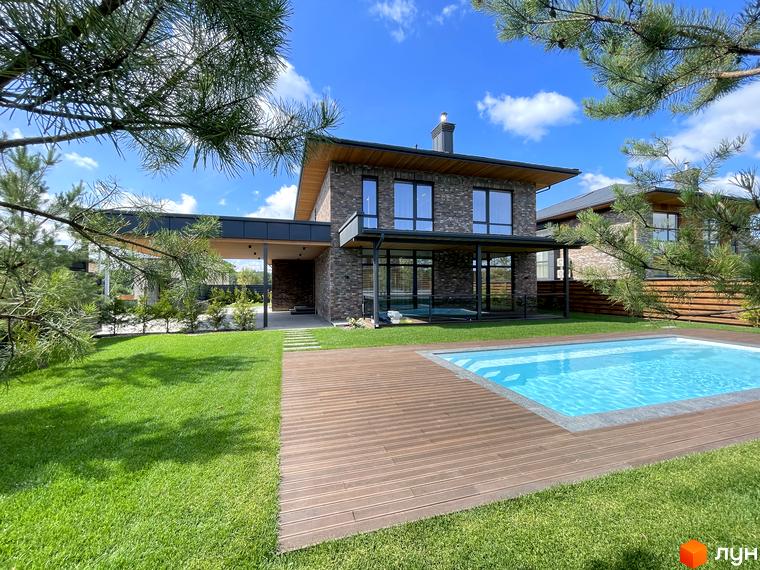 Зовнішній вигляд будинку КМ Нова Ходосівка з великою прибудинковою територією та басейном на фоні зеленого газону.