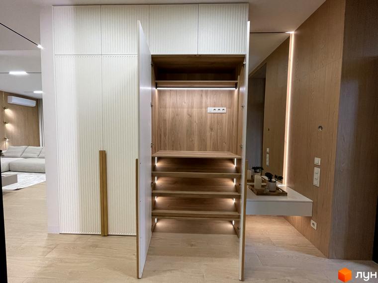 Внутрішній вигляд квартири в житловому комплексі КМ Нова Ходосівка з сучасним шафою та світлом. Затишна обстановка з елементами декору.