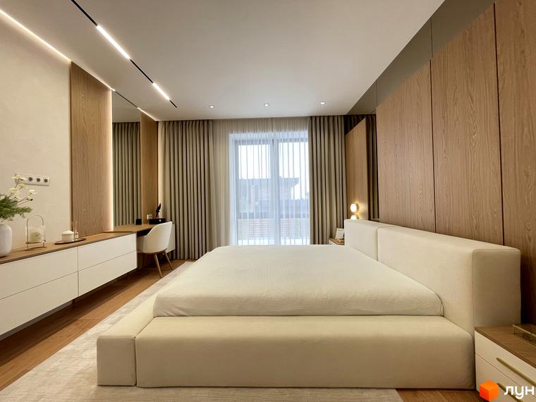 Сучасна спальня в житловому комплексі КМ Нова Ходосівка з великим вікном та дерев'яними елементами. Простора кімната з мінімалістичним дизайном.