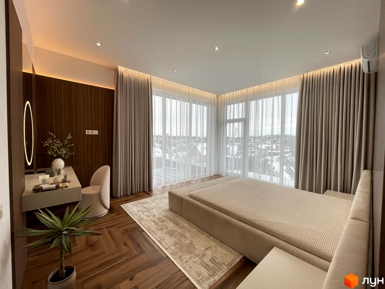 Сучасна спальня в житловому комплексі КМ Нова Ходосівка з великими вікнами та зручними меблями. Прибудинкова територія оформлена зеленими рослинами.