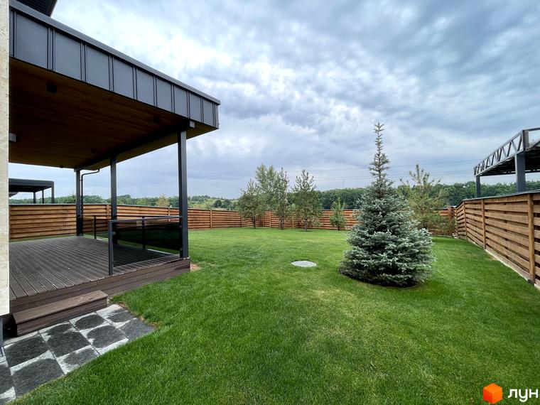 Зовнішній вигляд котеджного містечка КМ Нова Ходосівка з прибудинковою територією та зеленими насадженнями.