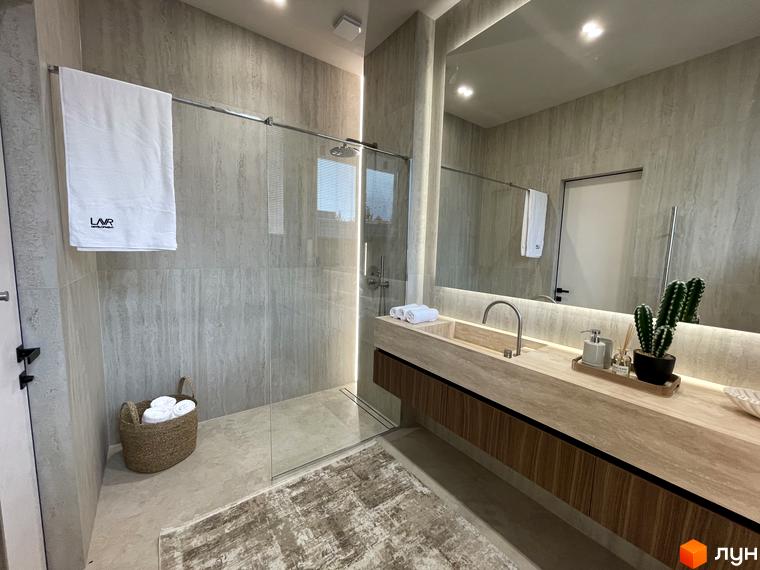 Сучасна ванна кімната з душовою кабіною, дерев'яною шафою та стильними аксесуарами. Приємна атмосфера з натуральними матеріалами.