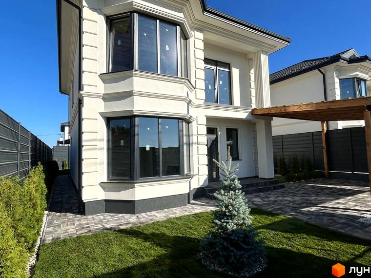 Зовнішній вигляд будинку Комплекс Благовісний з великими вікнами. Прибудинкова територія з газоном та озелененням.