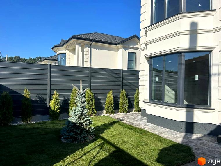 Зовнішній вигляд будинку Комплекс Благовісний з великими вікнами та прибудинковою територією з газоном та зеленими насадженнями.