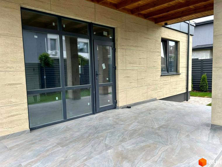 Зовнішній вигляд будинку Комплекс Прикордонний з великими вікнами та плитковою підлогою. Прибудинкова територія з газоном та огорожею.