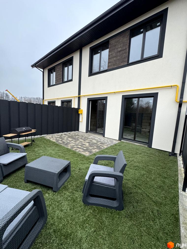 Зовнішній вигляд Таунхауси 40 Estates з прибудинковою територією та зоною відпочинку на зеленій траві.