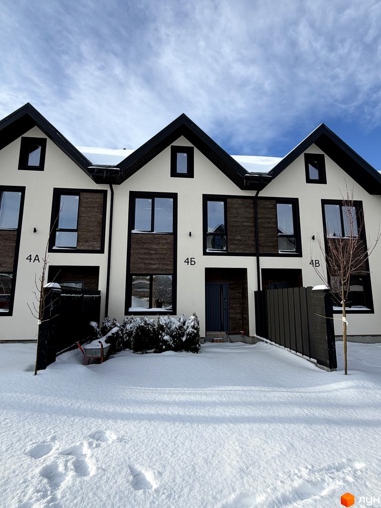 Фасад таунхаусів 40 Estates з великими вікнами, обрамленими деревом, та прибудинковою територією, засипаною снігом.