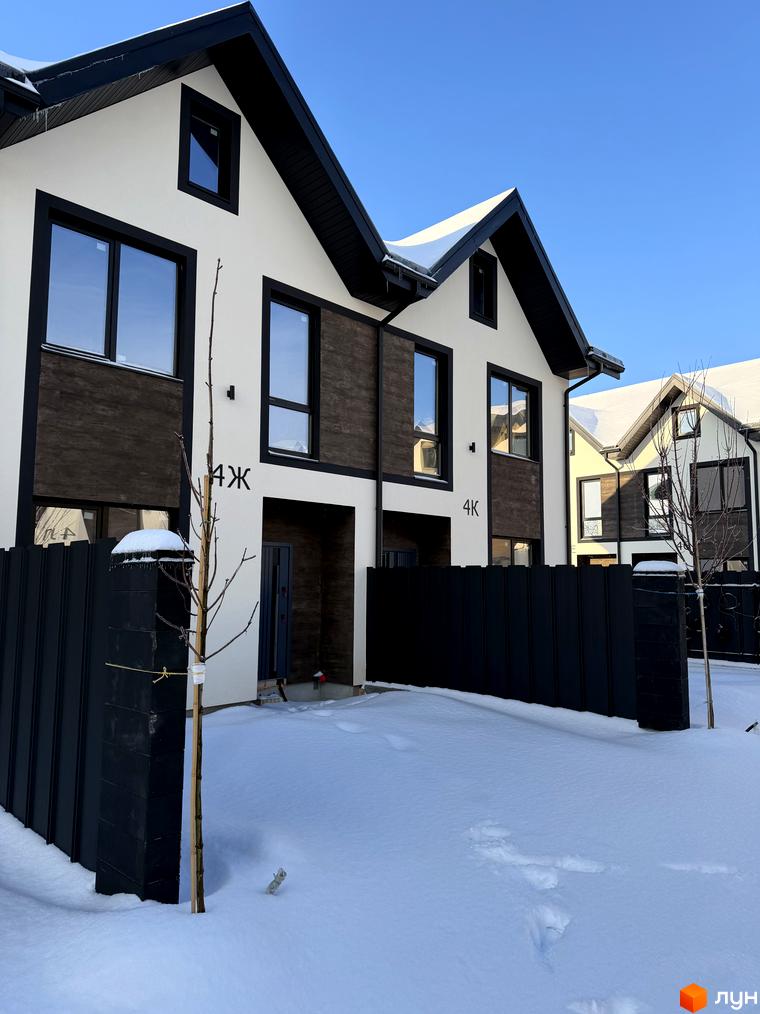 Сучасні таунхауси 40 Estates з великими вікнами та чорним парканом. Прибудинкова територія засипана снігом, з невеликими деревами.