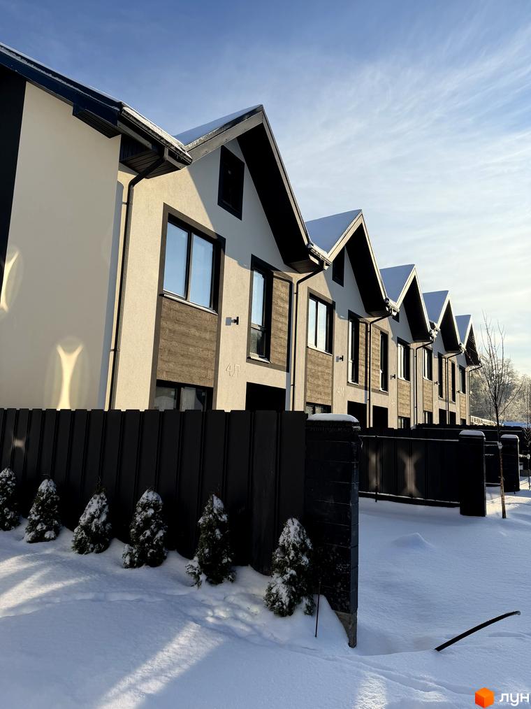 Вигляд таунхаусів 40 Estates з чорним парканом та засніженою прибудинковою територією. Будинки мають сучасні архітектурні форми.