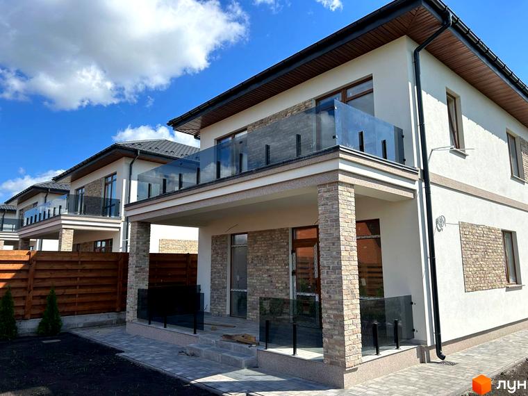 Зовнішній вигляд будинку в Комплекс Озерний з балконами та сучасними фасадами. Прибудинкова територія з вимощеною плиткою та зеленими насадженнями.