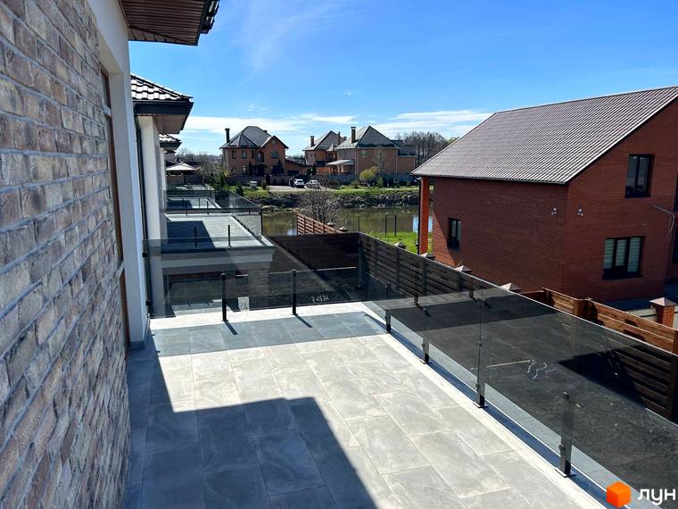 Зовнішній вигляд будинку Комплекс Озерний з терасою та скляними перилами. Прибудинкова територія з зеленими насадженнями та сусідніми будинками.