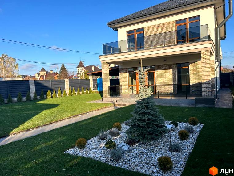 Зовнішній вигляд будинку Комплекс Незалежний з терасою та прибудинковою територією, озелененою газоном і декоративними рослинами.